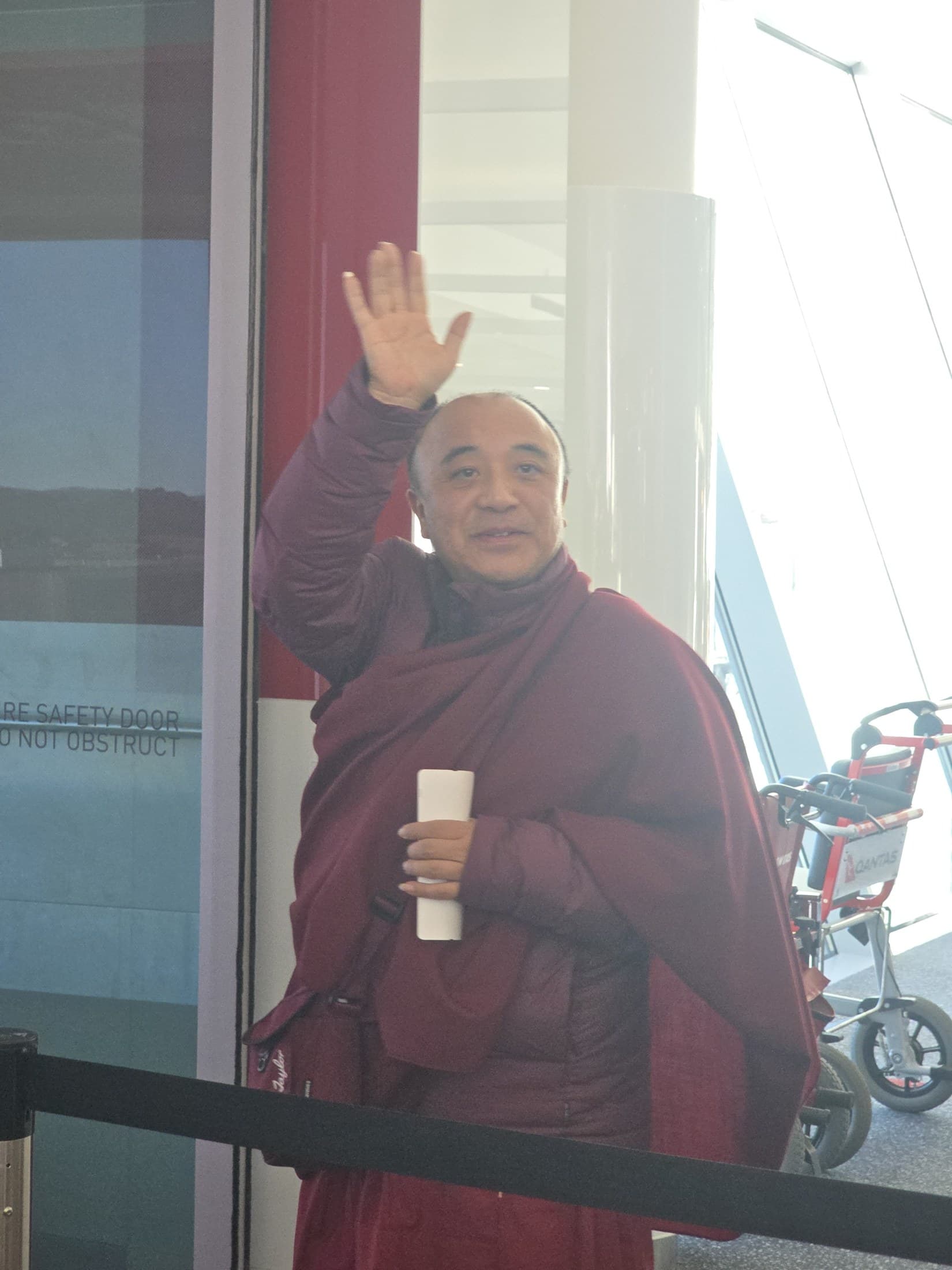 Kyabje Namkhai Nyingpo Rinpoche offering a final wave before boarding